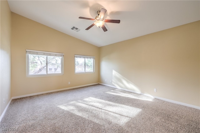 empty room with lofted ceiling, light colored carpet, and ceiling fan