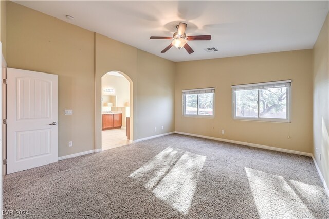 carpeted spare room featuring ceiling fan