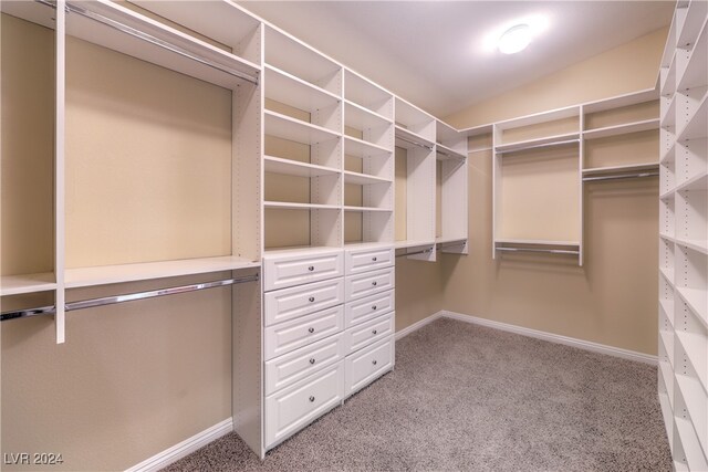 walk in closet featuring light carpet and vaulted ceiling