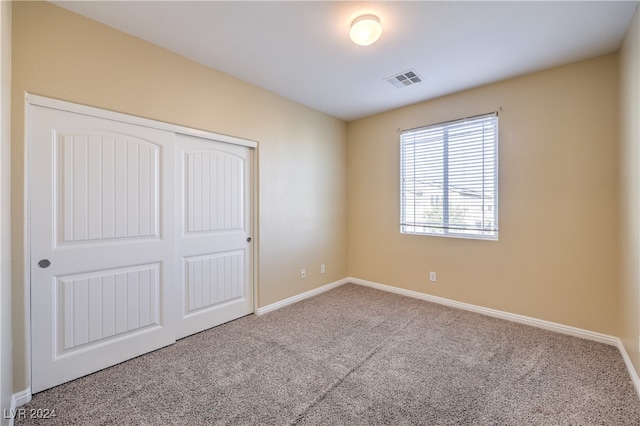 unfurnished bedroom with carpet flooring and a closet