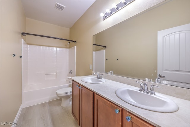 full bathroom featuring toilet, vanity, wood-type flooring, and shower / bath combination