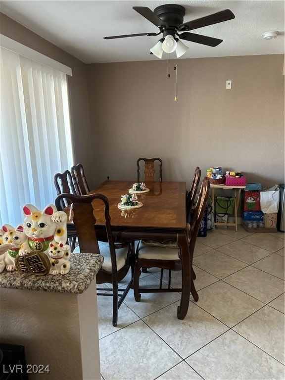 dining space with ceiling fan and light tile patterned flooring