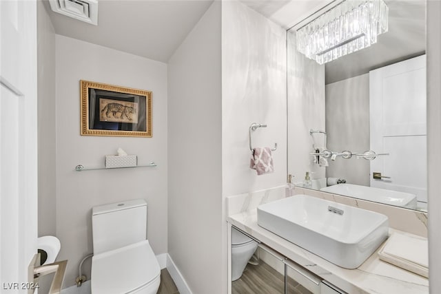 bathroom with vanity, toilet, and hardwood / wood-style flooring