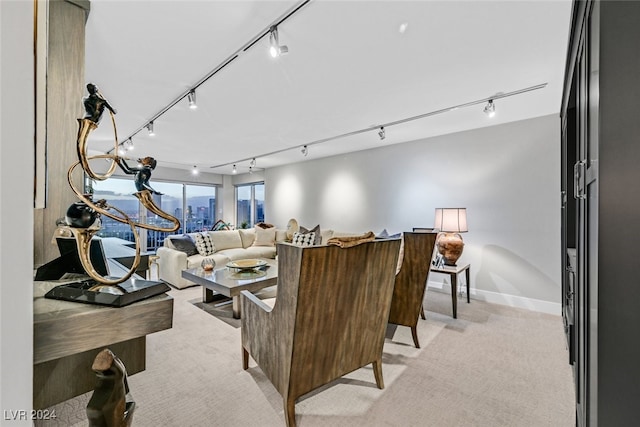 3111 Bel Air Dr Unit 25A, Las Vegas, NV 89109 - living room featuring rail lighting, light colored carpet, baseboards, and a view of city
