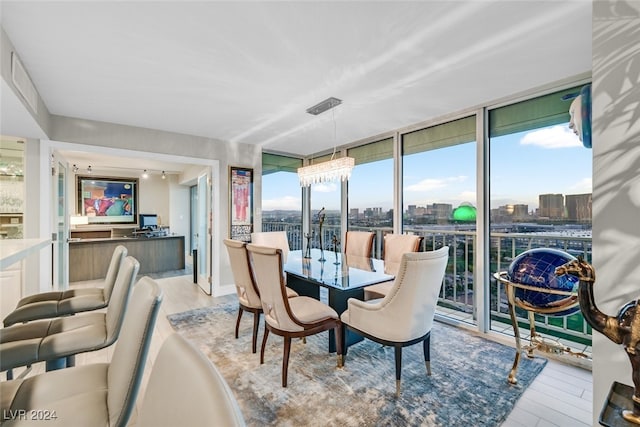 3111 Bel Air Dr Unit 25A, Las Vegas, NV 89109 - dining room with expansive windows, light wood finished floors, and a view of city