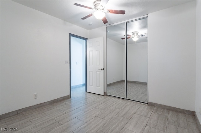 unfurnished bedroom featuring ceiling fan and a closet