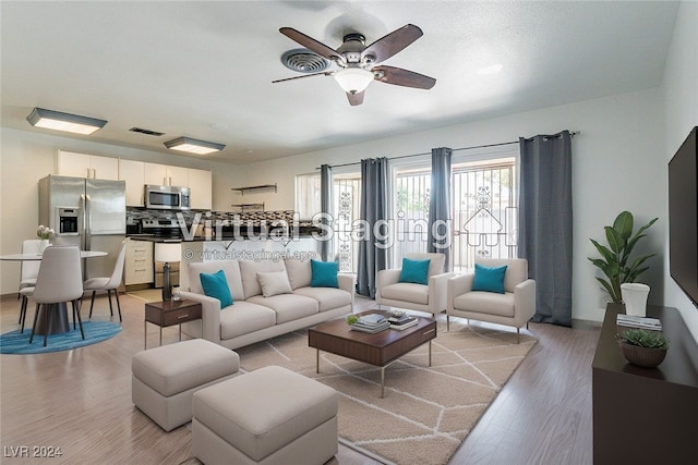 living room featuring light hardwood / wood-style flooring and ceiling fan