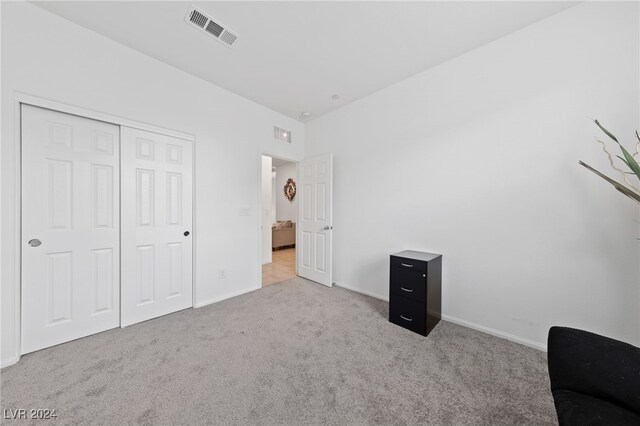 unfurnished bedroom with light carpet and a closet