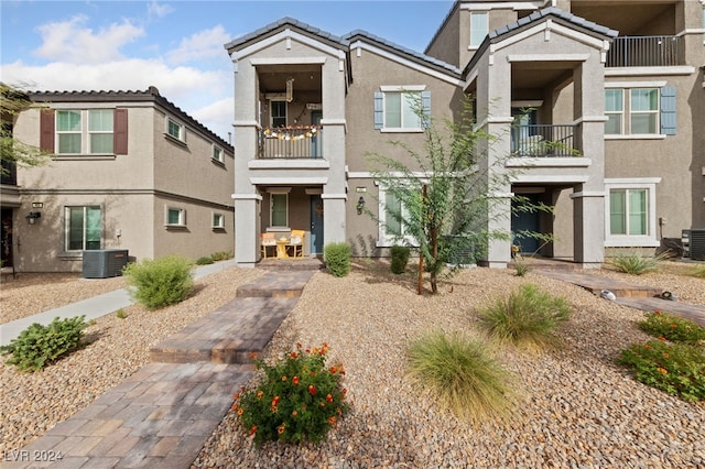 view of front of home featuring central air condition unit and a balcony