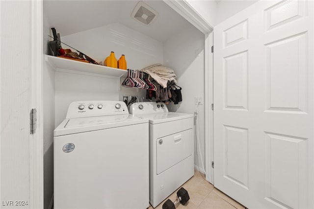 clothes washing area with light tile patterned flooring and independent washer and dryer