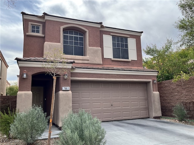 view of front of home featuring an attached garage, fence, concrete driveway, and stucco siding