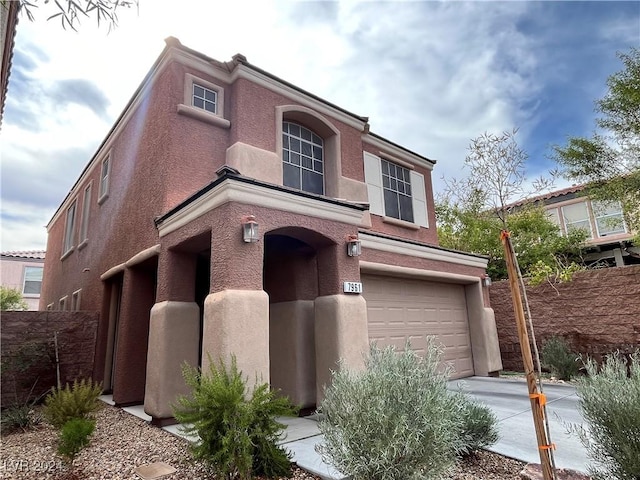 view of front of property featuring an attached garage, concrete driveway, and stucco siding