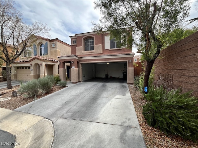 mediterranean / spanish house featuring stucco siding, fence, a garage, driveway, and a tiled roof