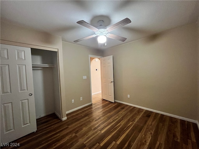 unfurnished bedroom with a closet, ceiling fan, and dark hardwood / wood-style floors