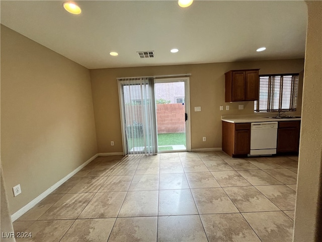 kitchen with dishwasher, sink, and light tile patterned floors