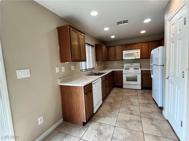 kitchen featuring light countertops, visible vents, light tile patterned flooring, a sink, and white appliances