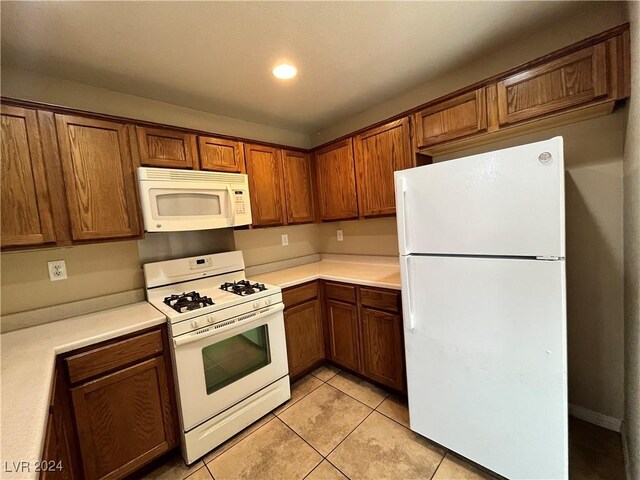 kitchen with light tile patterned floors and white appliances