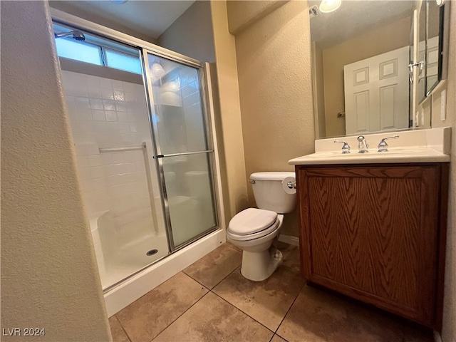 bathroom with vanity, tile patterned floors, toilet, and walk in shower