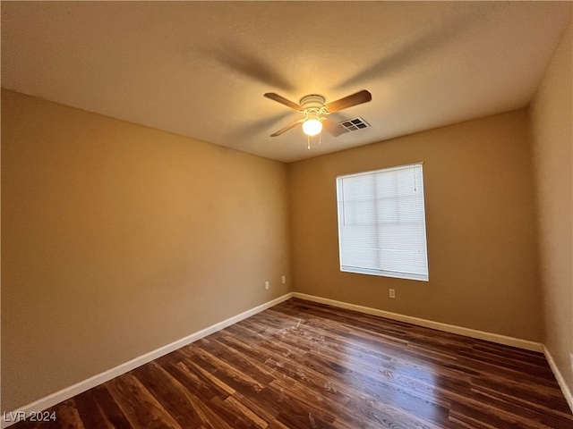 spare room featuring dark wood-type flooring and ceiling fan