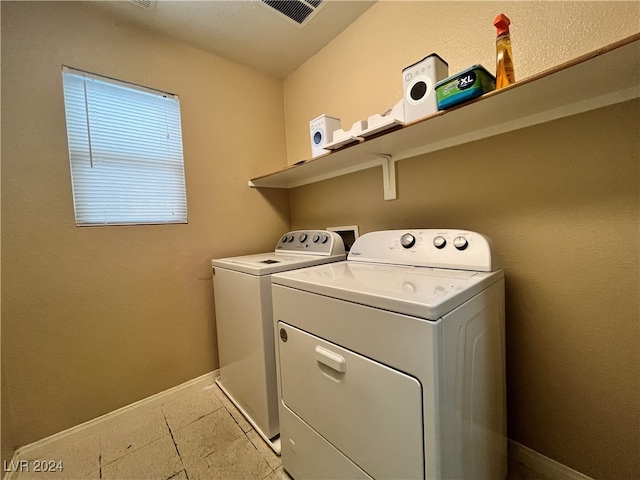 laundry room with light tile patterned flooring and separate washer and dryer