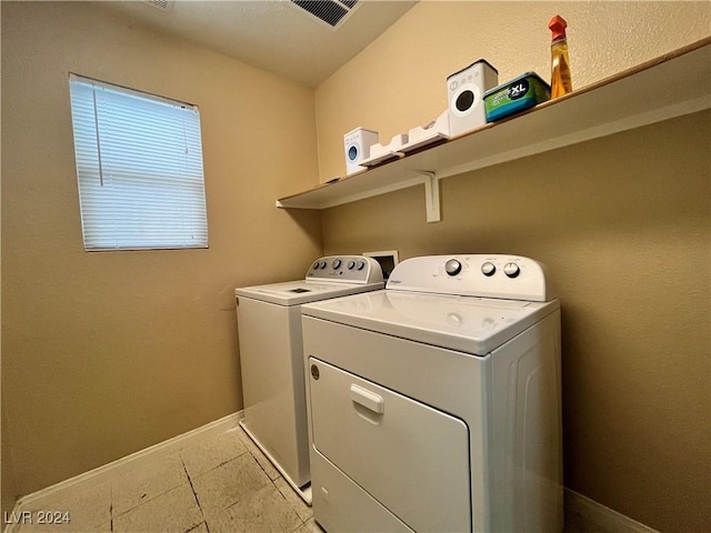 washroom with washer and dryer, laundry area, visible vents, and baseboards