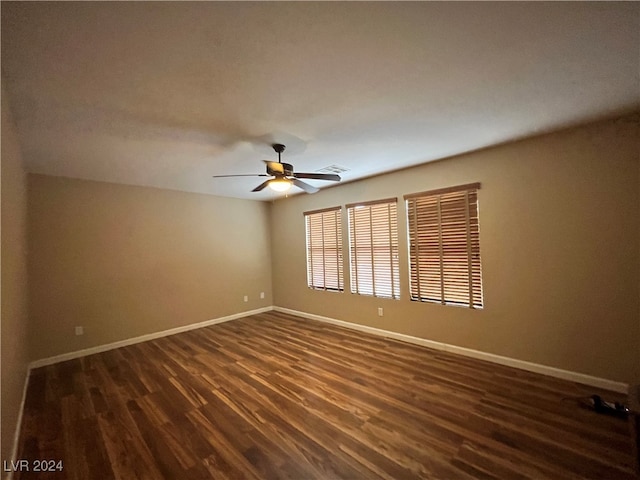 empty room with dark wood-type flooring and ceiling fan