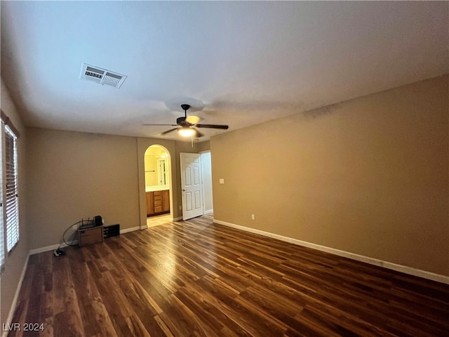 empty room with ceiling fan and dark hardwood / wood-style flooring