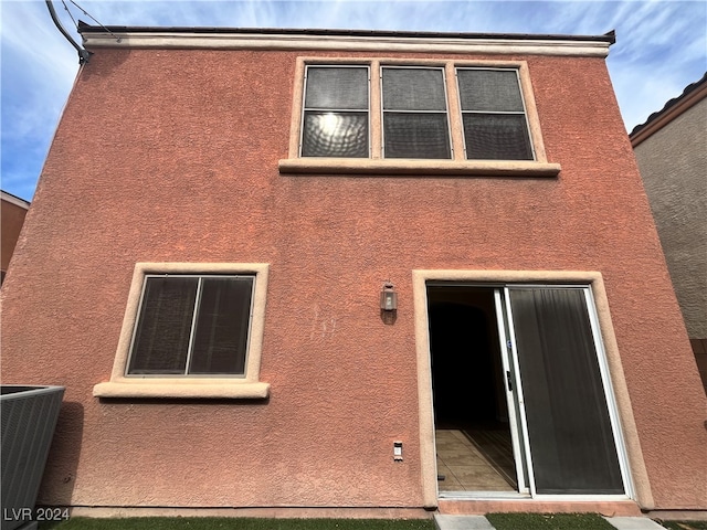 rear view of property with cooling unit