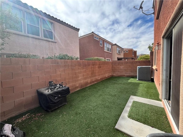 view of yard with a fenced backyard and central air condition unit