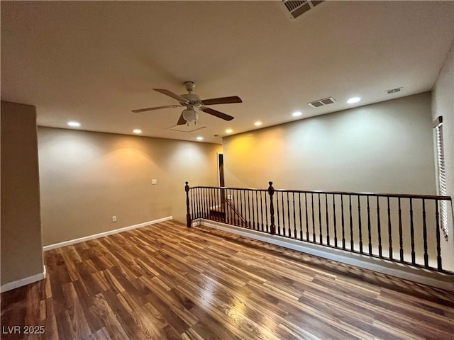 spare room featuring dark wood-type flooring, visible vents, and recessed lighting