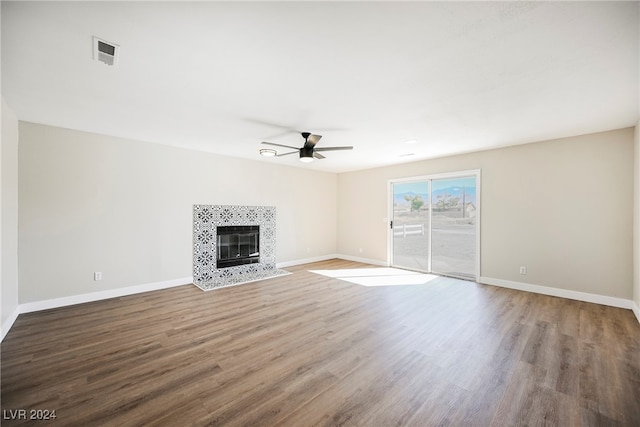 unfurnished living room featuring hardwood / wood-style floors, ceiling fan, and a fireplace