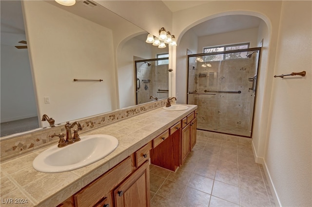 bathroom with vanity, a shower with shower door, and tile patterned floors