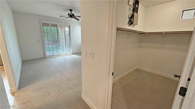 walk in closet featuring light colored carpet and ceiling fan