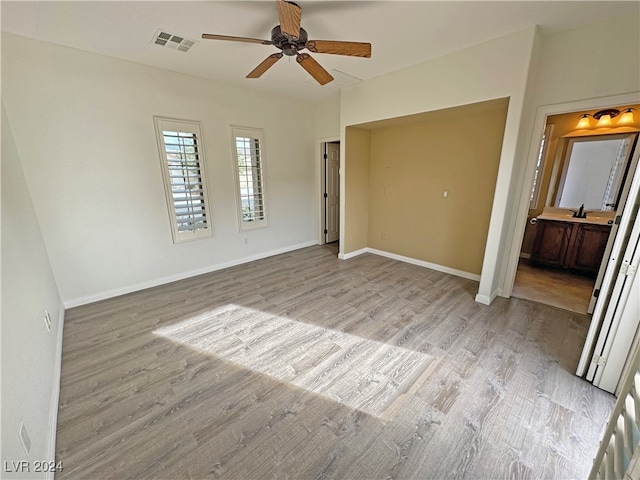 interior space with light hardwood / wood-style floors, ensuite bathroom, sink, and ceiling fan