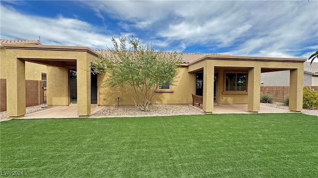 back of house with a patio area and a lawn