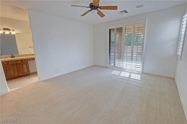 carpeted spare room with sink and ceiling fan