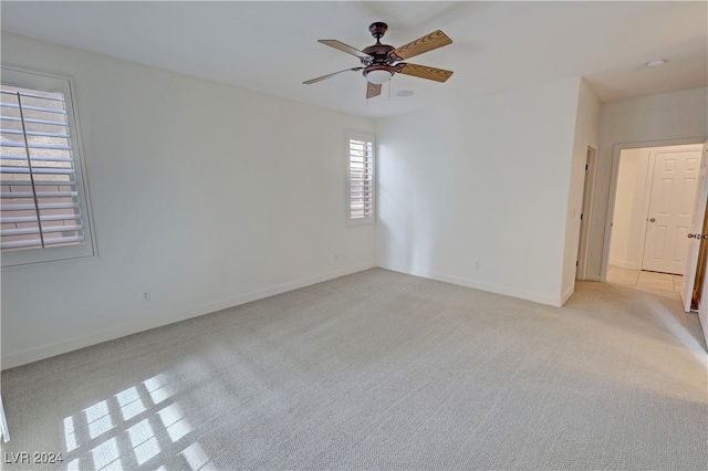 unfurnished room featuring ceiling fan and light colored carpet