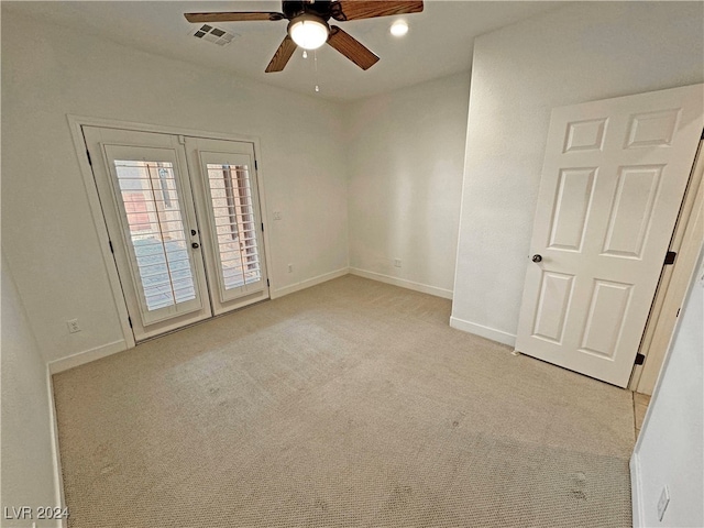 carpeted spare room with french doors and ceiling fan