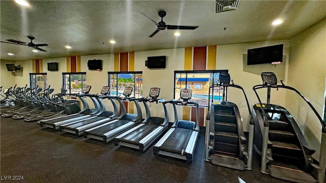 gym with ceiling fan and a textured ceiling