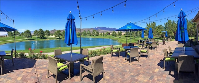 view of patio / terrace featuring a water and mountain view