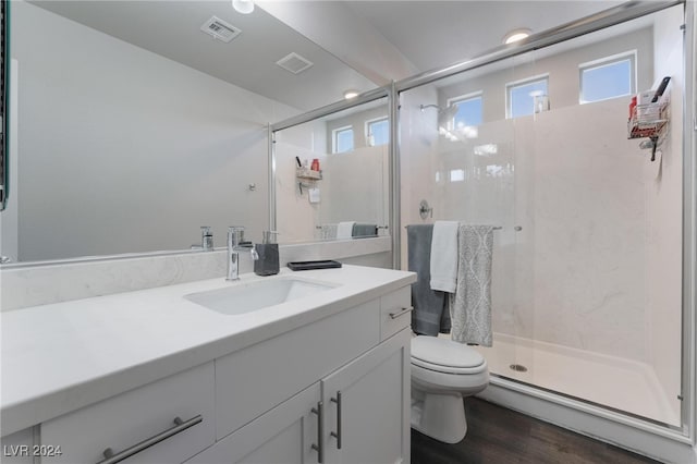 bathroom with vanity, toilet, an enclosed shower, and hardwood / wood-style floors