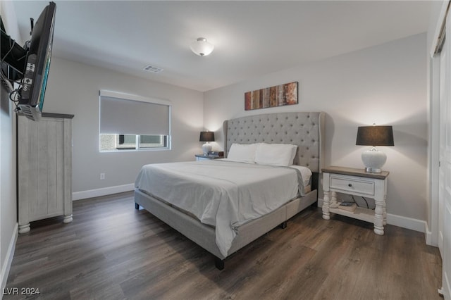 bedroom with dark hardwood / wood-style floors