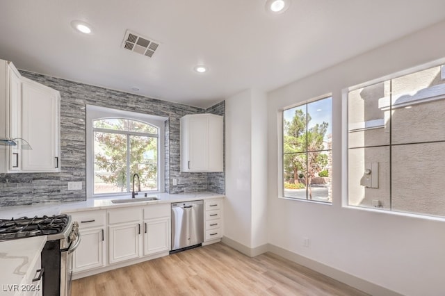 kitchen with sink, white cabinets, and stainless steel appliances