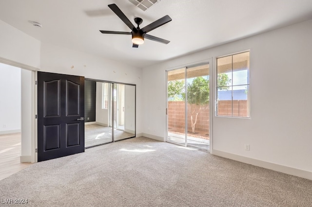 unfurnished bedroom featuring ceiling fan, access to outside, and light colored carpet