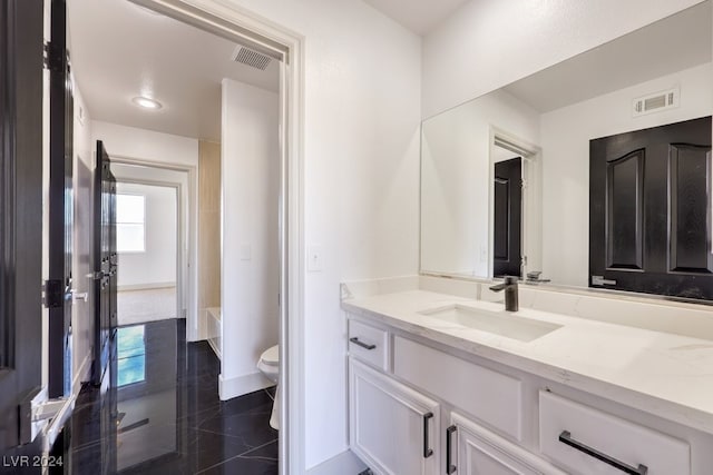 bathroom with vanity, toilet, and tile patterned flooring