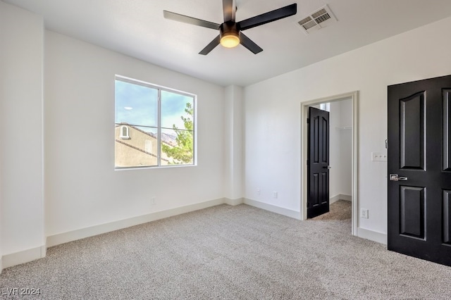 spare room featuring light colored carpet and ceiling fan