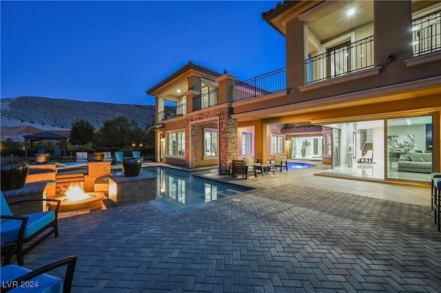 view of pool featuring a mountain view, a patio area, and an outdoor fire pit