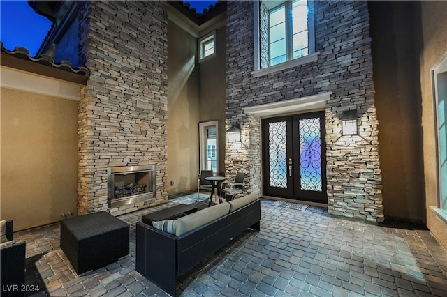 view of patio / terrace featuring an outdoor stone fireplace and french doors