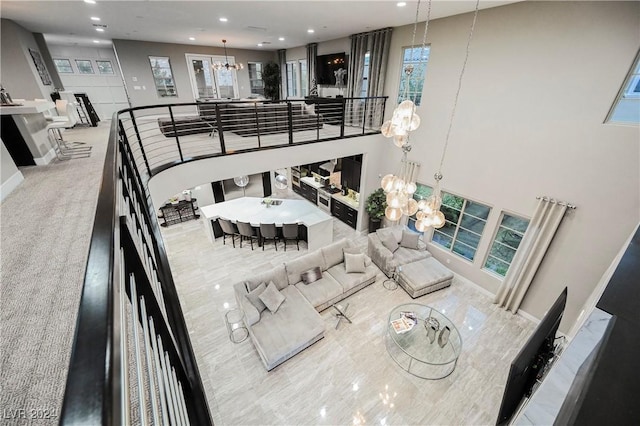 interior space featuring a healthy amount of sunlight, a notable chandelier, and a high ceiling