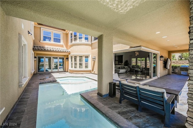 rear view of house with french doors, an outdoor living space, a patio area, and an indoor pool